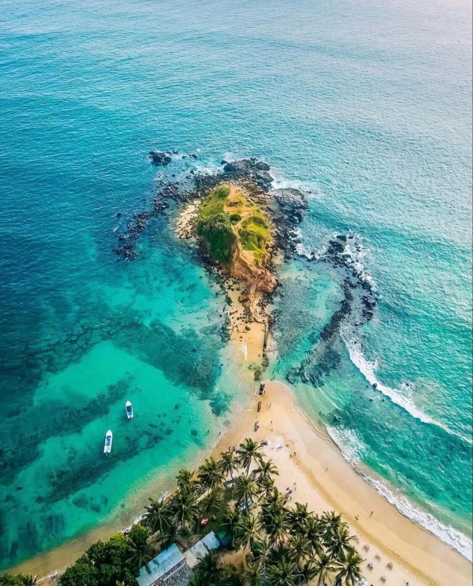 Aerial view of a small green island surrounded by turquoise water off Sri Lanka's southern coast.